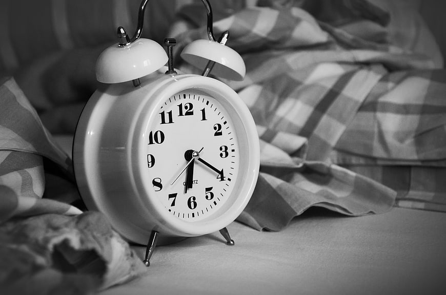 Vintage White Alarm Clock on Plaid Bedding in Black and White