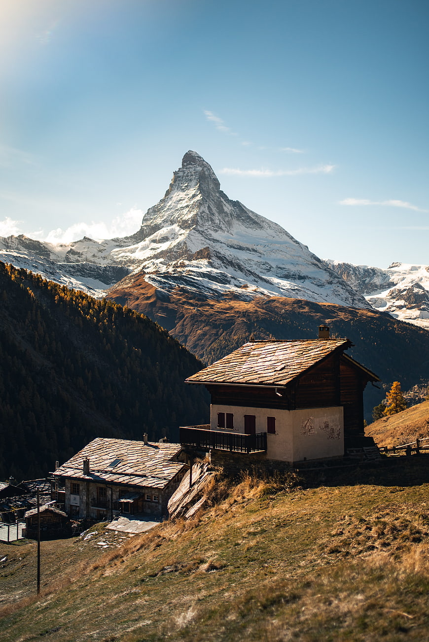 Matterhorn mountain peak with traditional Swiss chalets in autumn