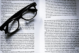 Black eyeglasses resting on open book pages