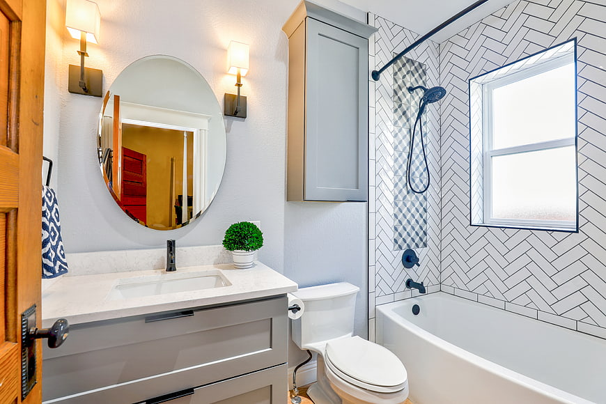 Modern bathroom with herringbone tile and gray vanity
