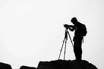 Silhouette of Photographer with Camera on Tripod