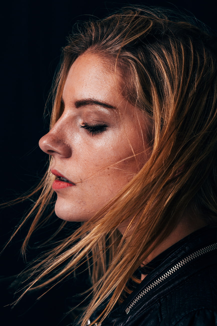 Close-up portrait of woman with windblown hair and leather jacket