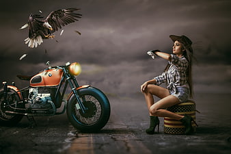 Woman with eagle and vintage motorcycle in cinematic style