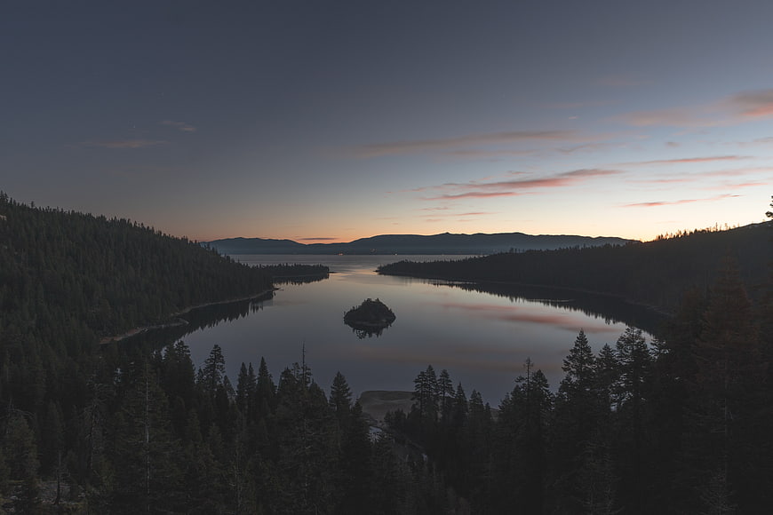 Serene Lake Sunset with Forest Silhouettes and Mountain Reflection