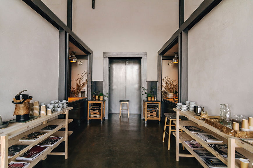 Modern industrial interior with wooden shelves and metal door