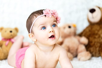 Adorable baby girl with blue eyes and pink flower headband