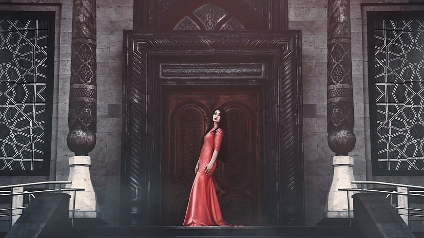 Woman in Red Gown Standing Before Ornate Wooden Door