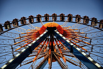Low angle view of illuminated Ferris wheel against blue sky