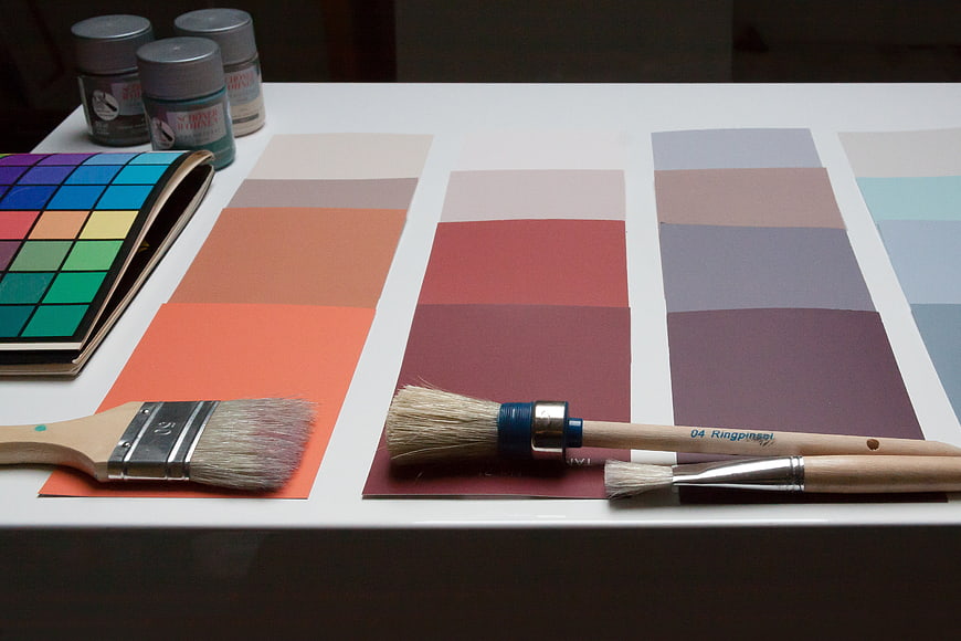 Interior design color palette samples and paint brushes on white table