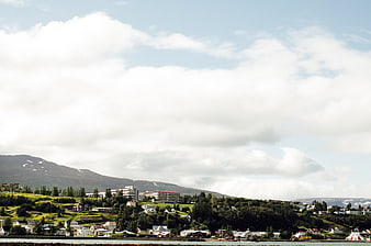 Coastal town with mountains and cloudy sky