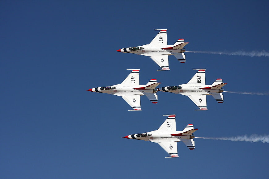 USAF Thunderbirds Diamond Formation Flight Against Blue Sky