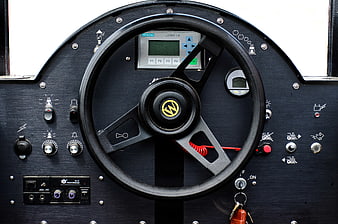 Close-up of black industrial steering wheel and control panel