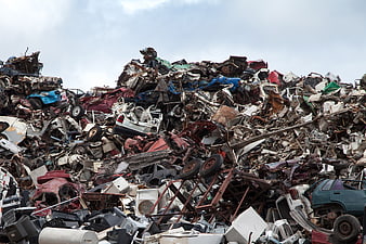 Massive pile of crushed cars and scrap metal in junkyard