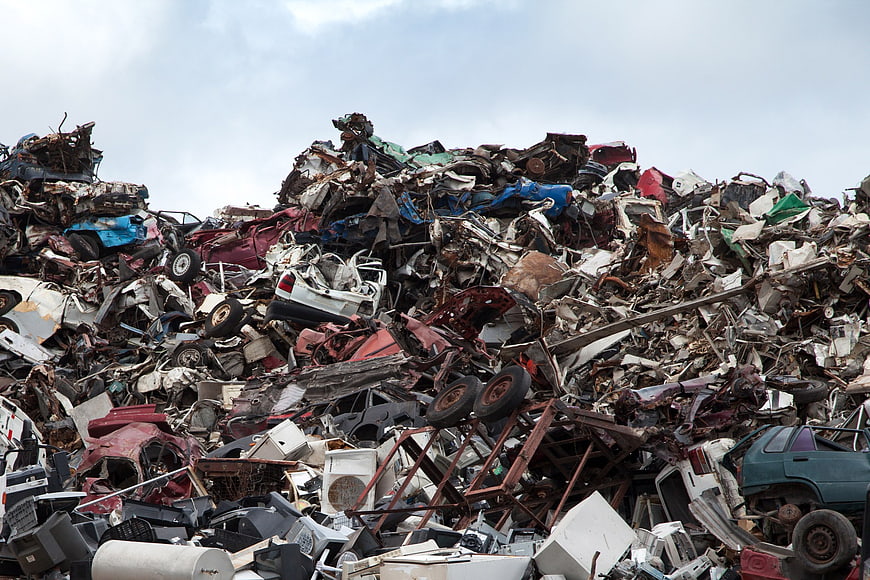Massive pile of crushed cars and scrap metal in junkyard