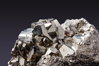 Close-up of metallic pyrite crystals on dark background