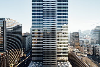 Tall modern skyscraper in urban cityscape with glass facade