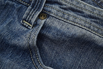 Close-up of blue denim jeans pocket with brass button