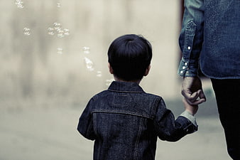 Child holding adult hand watching bubbles