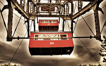 Red Ferris Wheel Cabins Against Dramatic Sky