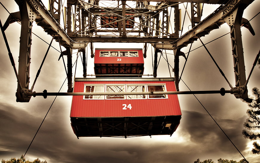 Red Ferris Wheel Cabins Against Dramatic Sky