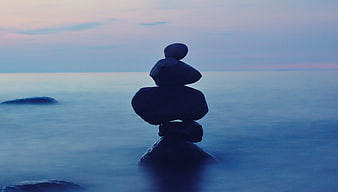 Stacked Balance Stones on Ocean at Dusk