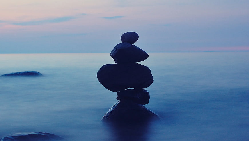 Stacked Balance Stones on Ocean at Dusk