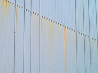 Abstract Rust Streaks on White Corrugated Metal Wall