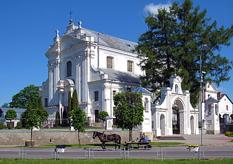 White Baroque Church with Horse-Drawn Cart on Sunny Day