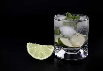 Refreshing Caipirinha Cocktail with Lime and Mint on Black Background