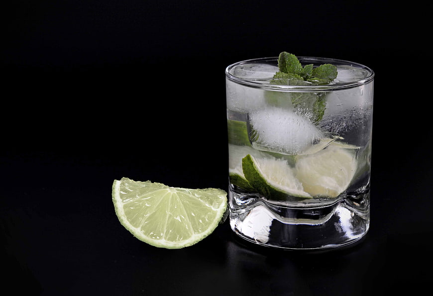 Refreshing Caipirinha Cocktail with Lime and Mint on Black Background