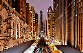 Night view of Chicago train tracks leading to skyscrapers