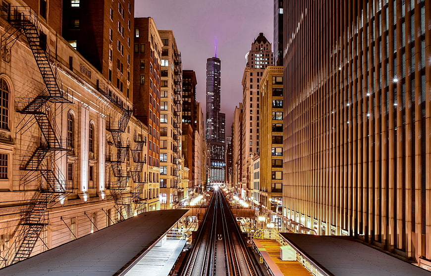 Night view of Chicago train tracks leading to skyscrapers