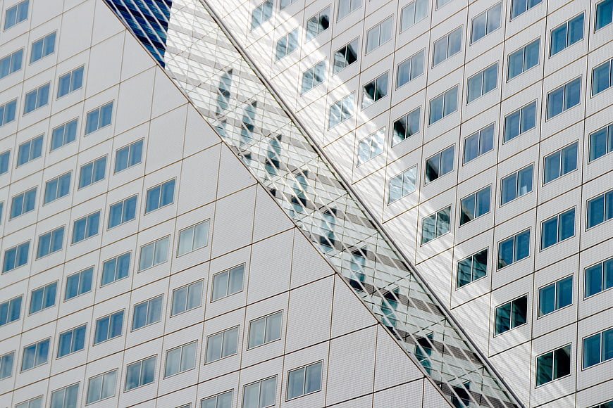 Modern white skyscraper facade with diagonal glass structure