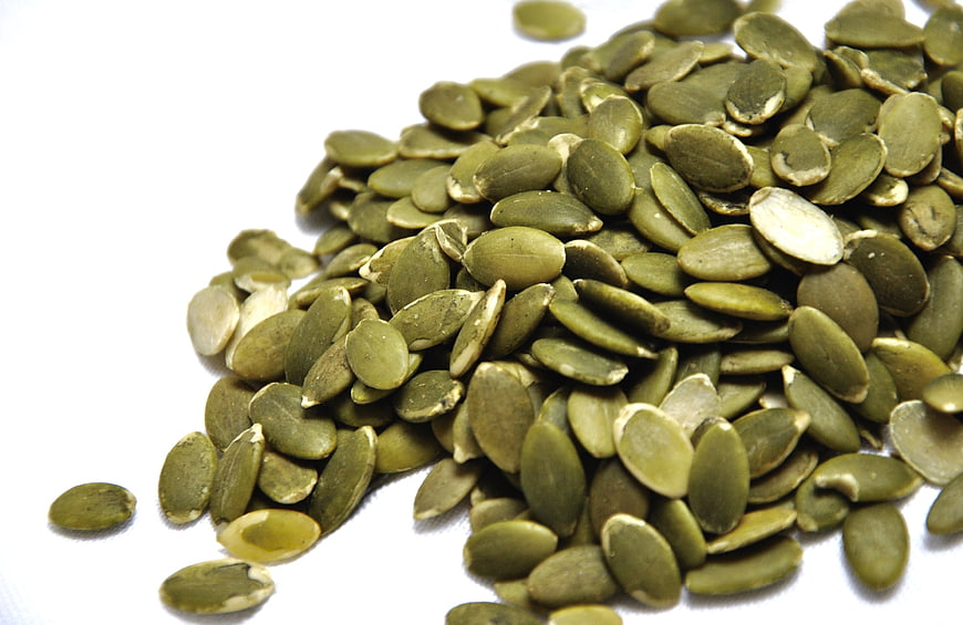 Pile of Green Pumpkin Seeds on White Background