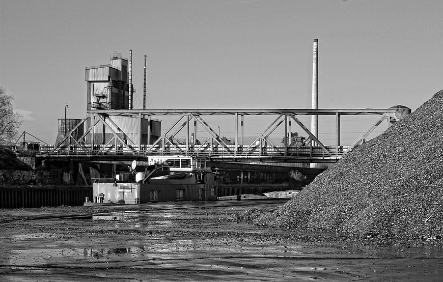 Black and white industrial landscape with bridge and coal pile