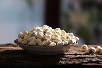 Bowl of Dried Lotus Seeds on Rustic Wooden Table