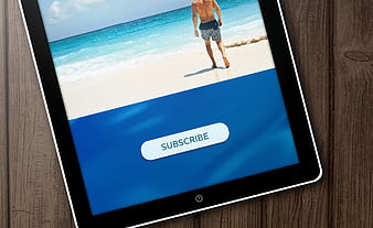 Tablet displaying subscribe button on beach background