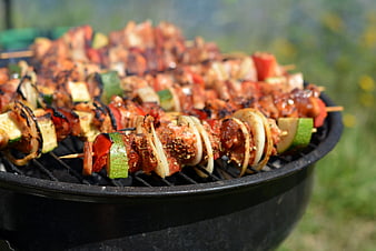 Grilled meat and vegetable skewers on outdoor barbecue