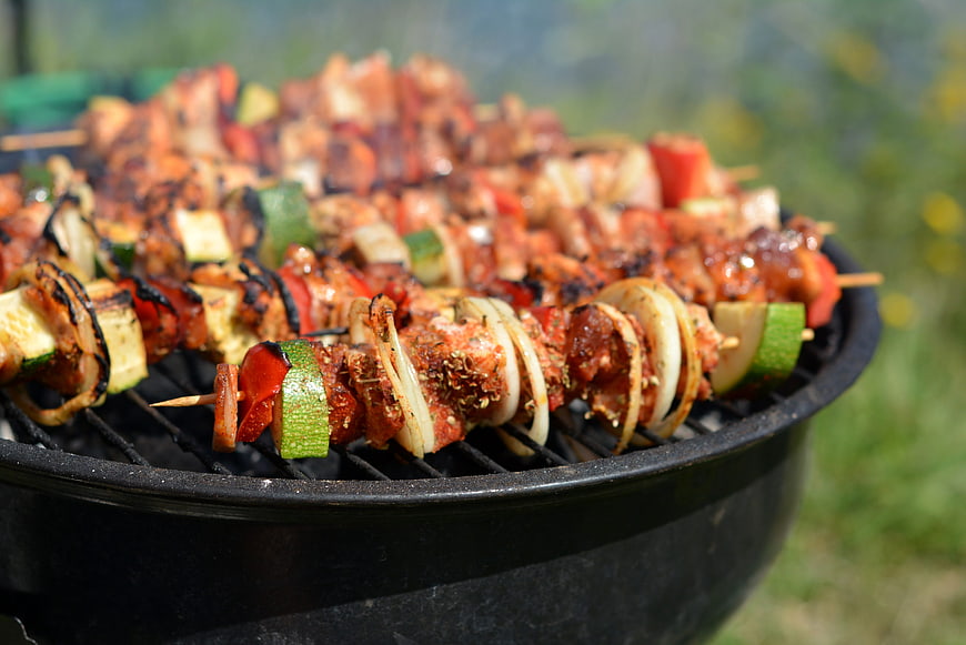 Grilled meat and vegetable skewers on outdoor barbecue