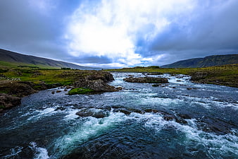 Dramatic River Landscape with Rushing Water and Cloudy Sky