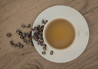 Top View of Coffee Cup with Beans on Wooden Table
