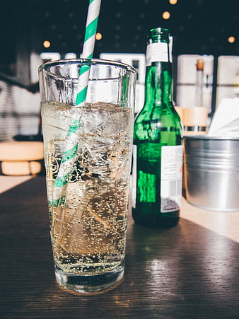 Refreshing Sparkling Drink with Green Bottle and Striped Straw