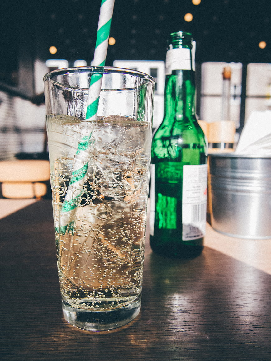 Refreshing Sparkling Drink with Green Bottle and Striped Straw