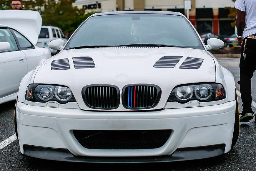 Front View of White BMW M3 with Hood Vents and M Stripes