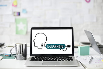 Laptop displaying e-learning concept with head and USB plug icon on desk