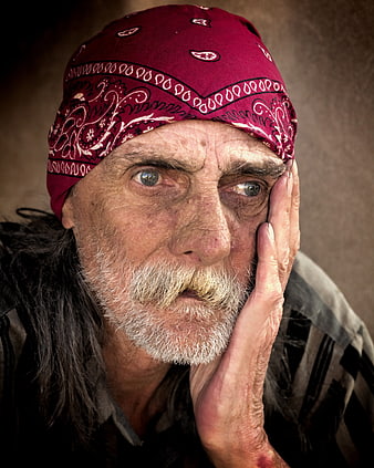 Portrait of elderly homeless man with red bandana