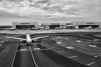 Black and white airplane taxiing on airport runway