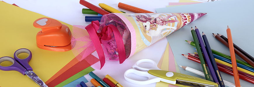 Colorful school supplies and party cone on desk