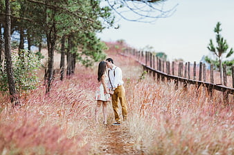 Romantic Couple Kissing in Pink Muhly Grass Field