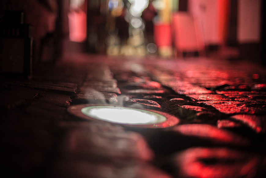 Wet cobblestone street with glowing light at night